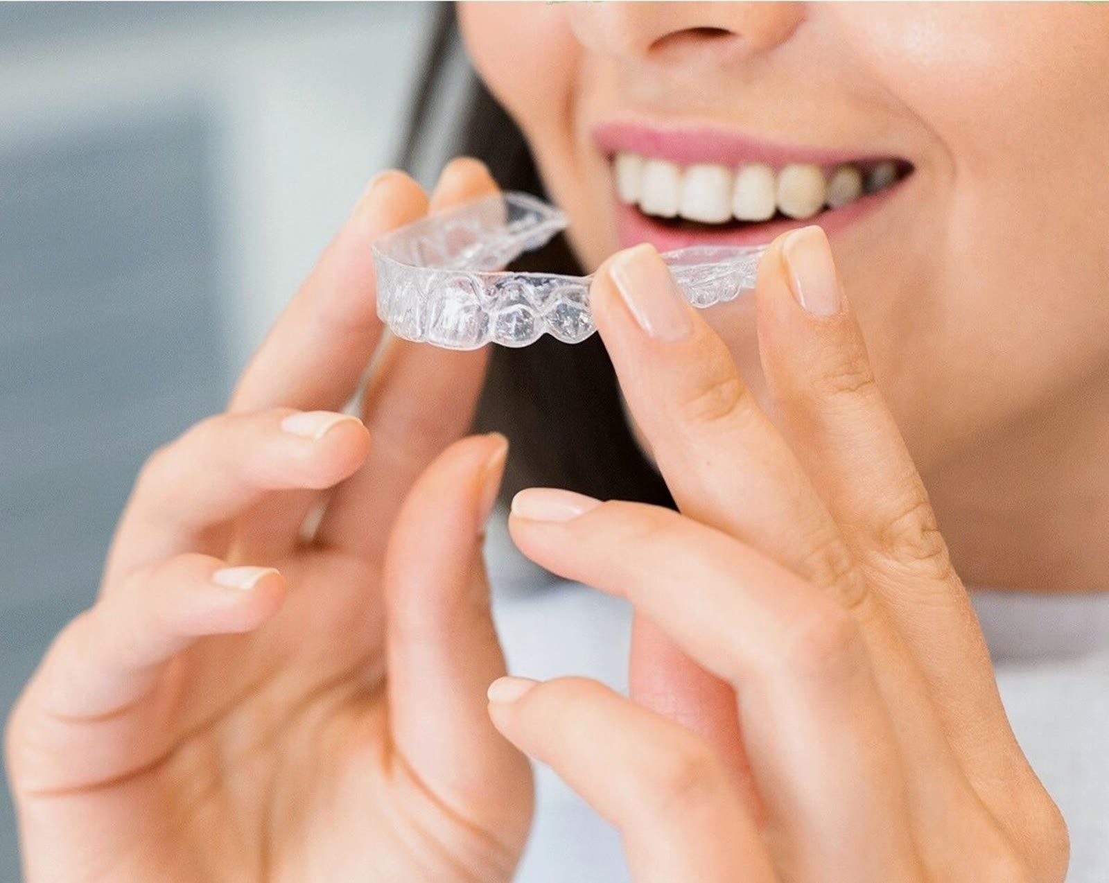 Zakładanie przezroczystej nakładki Invisalign na zęby